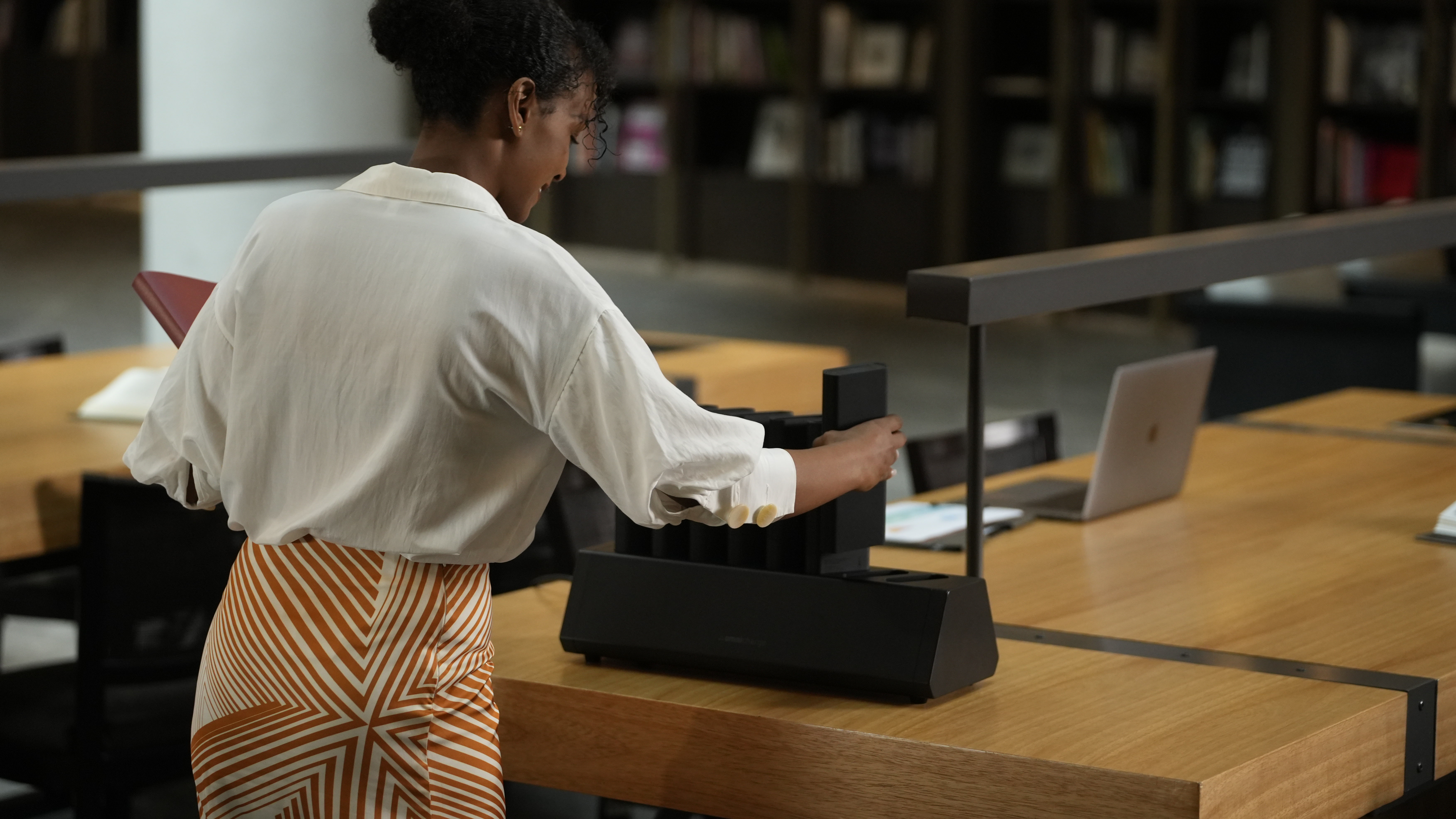 Estudiante retira una batería de la Omni Power Station en una biblioteca